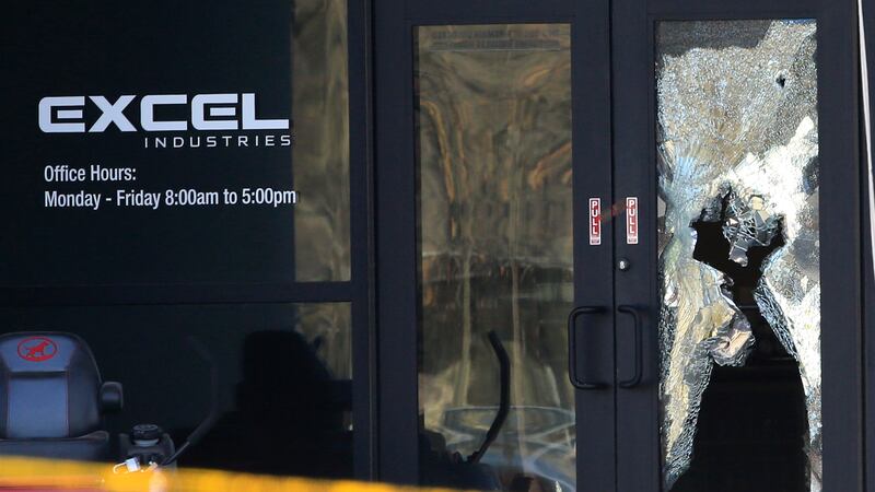 Shattered glass and bullet holes are seen at the front door of Excel Industries in Hesston,...